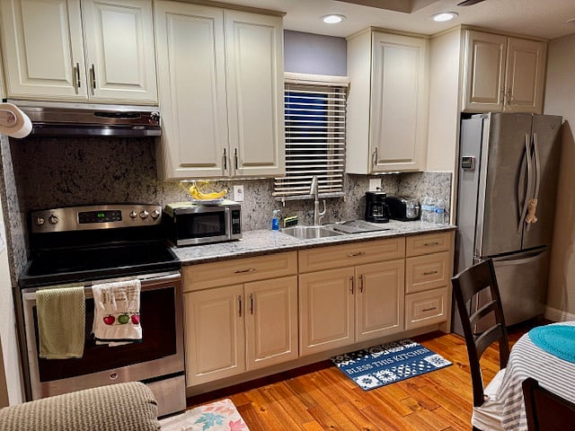 Kitchen with full size ceramic cooktop (4 burners), full size oven, microwave, quartz counter, stainless steel double sink, soft close kitchen drawers, full size side by side refrigerator swing double doors with bottom freezer.