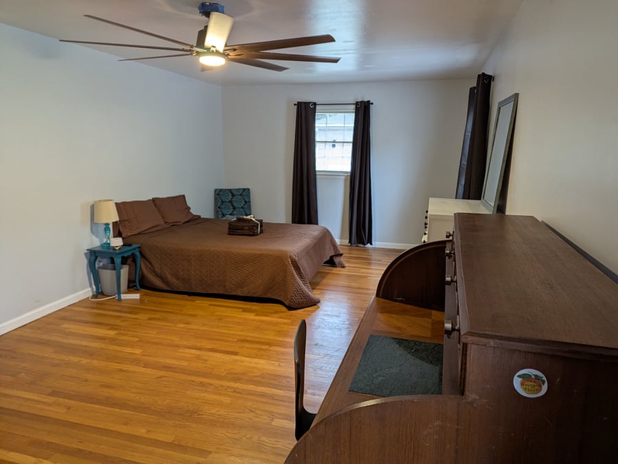 Master bedroom is approx 435 sqft with blackout curtains, roll top desk, dresser and mirror. Curtains open