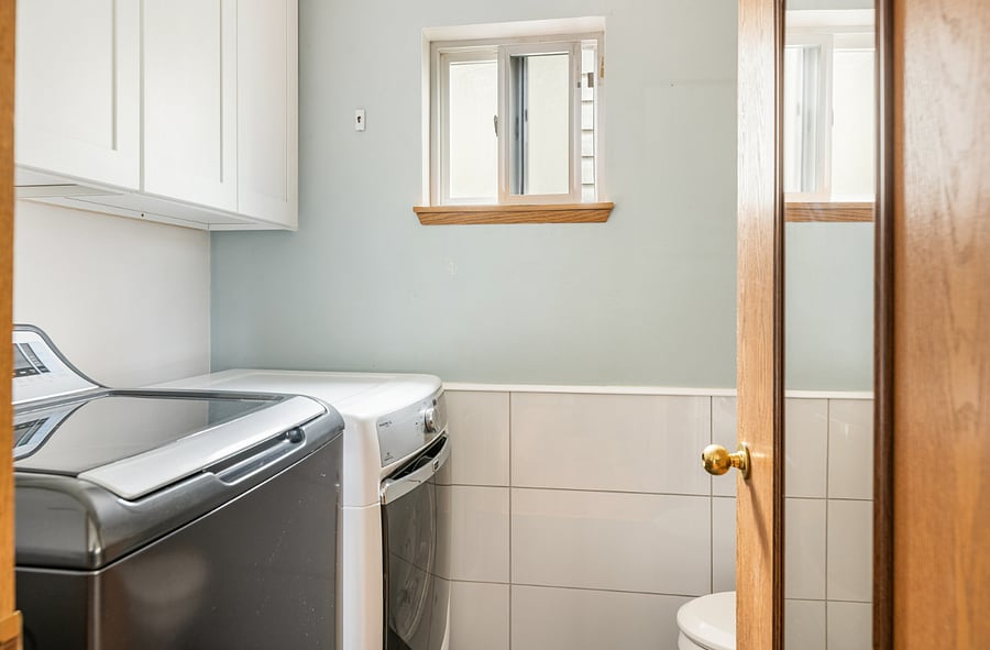 extra high tiled walls in this 1/2 bath make for easy cleaning with private exterior window and plenty of built in storage along with radiant heat floors!