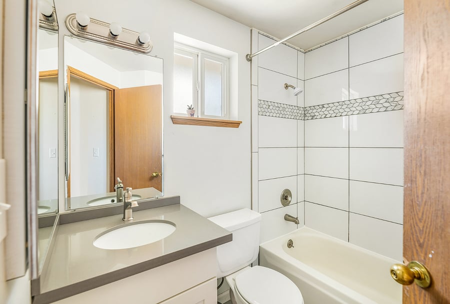deep steel soaking tub with updated tile throughout and radiant heat floors
