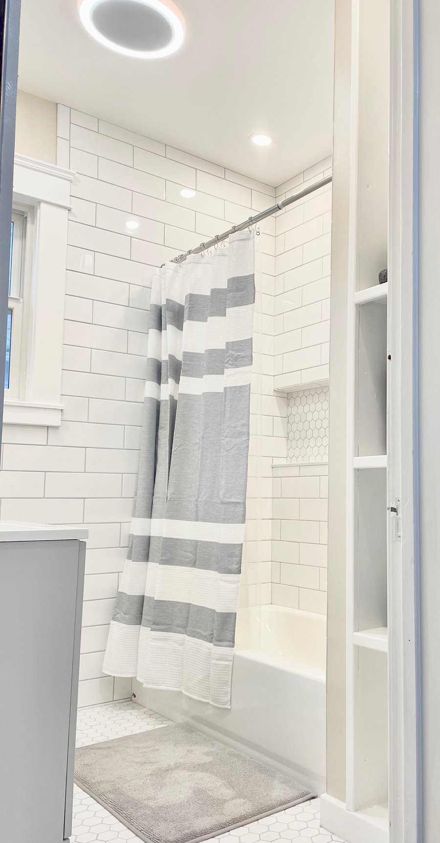 Newly renovated tile bathroom with a beautiful accent storage niche in the shower.