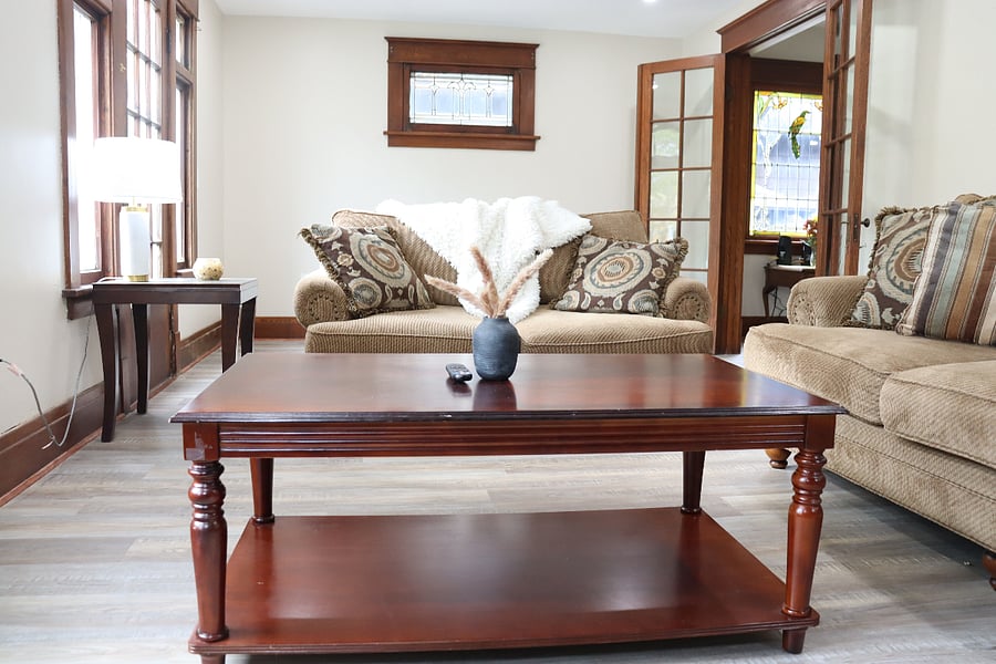 Very comforable couch and loveseat in the living room with stunning original woodwork surrouding the windows.