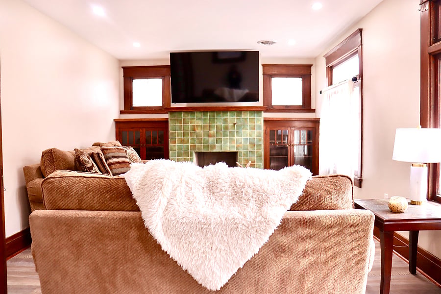 Original tile fireplace, woodwork accents and a smart TV with comfortable couches to lay and relax