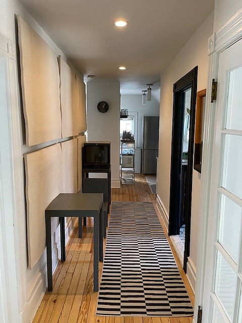 Facing the Kitchen Dining areas from long hallway filled with artist work