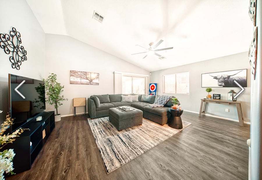 Living room with large L shaped couch, a desk for laptop.