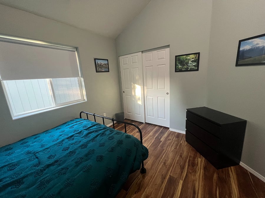 Bedroom with queen bed, desk, dresser, closet