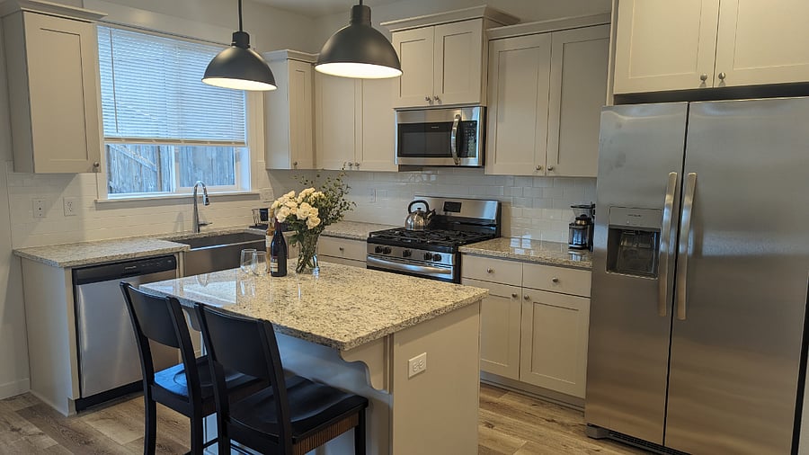 Fully stocked kitchen with dishware, silverware, pots and pans