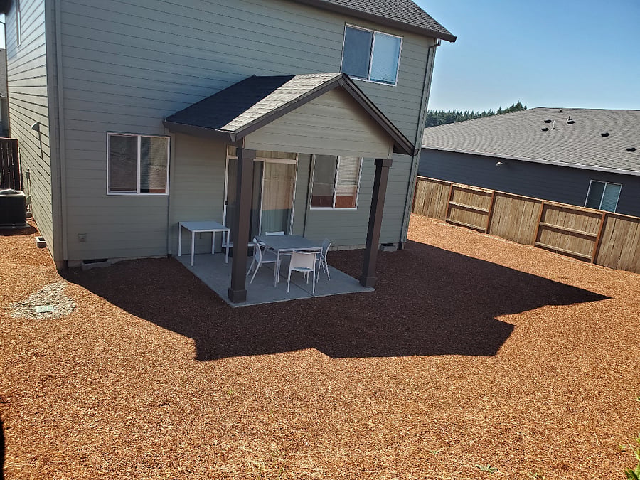Fenced back yard with gate. A gas grill is available for outdoor use.