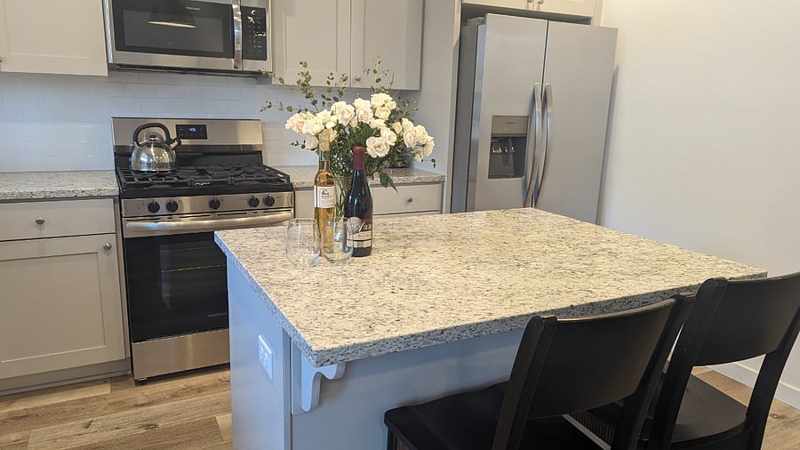 Fully stocked kitchen with dishware, pots and pans, and appliances.