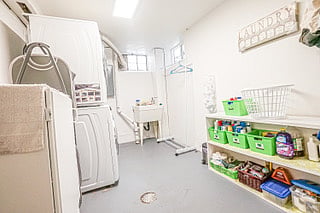 Shared Laundry Room with essenstials supplies such as: Detergent, Fabric Softener, Bleach, Clothes Dryer, Iron, and Steamer.  
