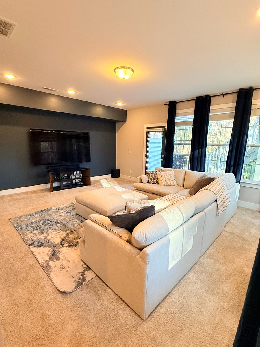 Downstairs theatre room with 85" TV, surround sound, gaming console and blackout curtains