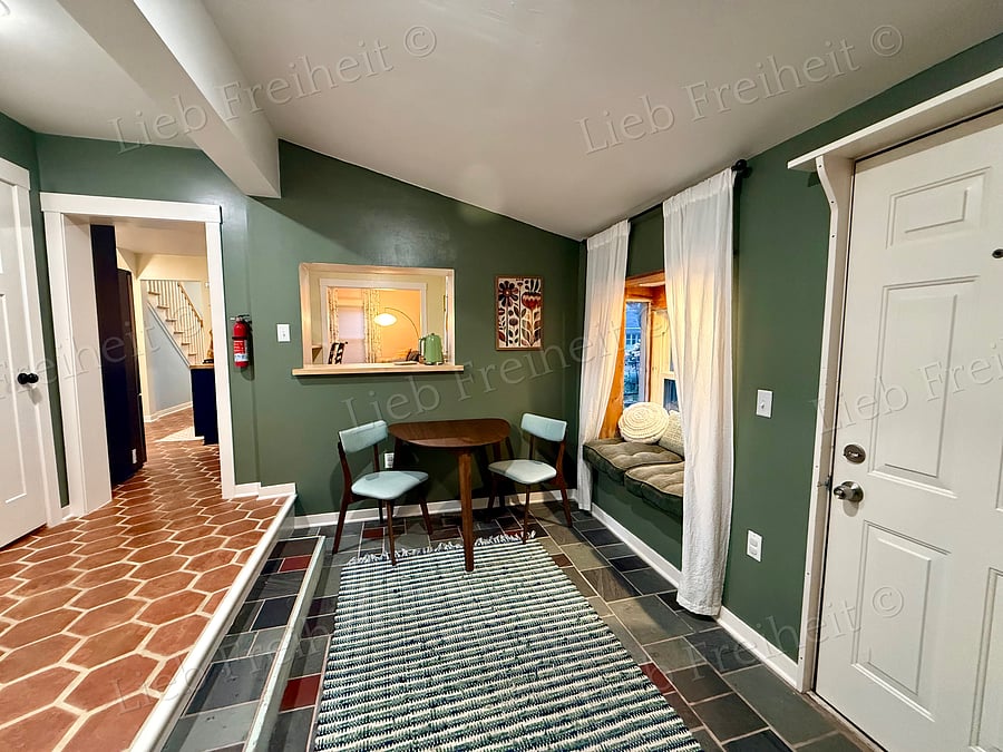 Downstairs flex space, includes small table, two reading nooks and small office area.