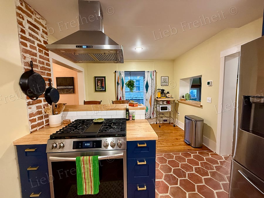 Kitchen on main floor. Stove backs up to eating area and coffee/tea/microwave cart