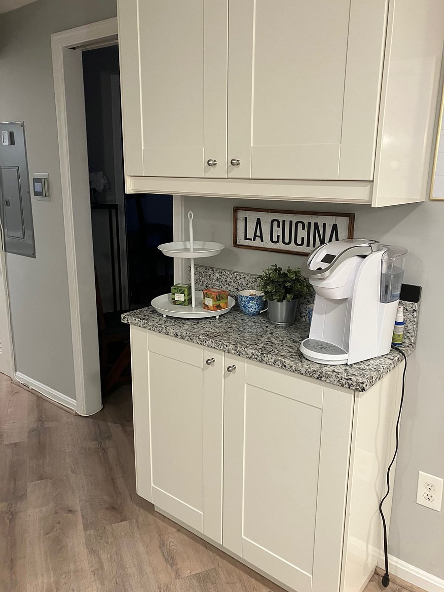 Kitchen cabinets and coffee area. Door leads into bedroom 2.