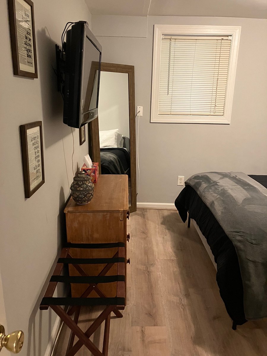 Bedroom 1: Queen bed, wall-mounted TV, dresser and mirror.