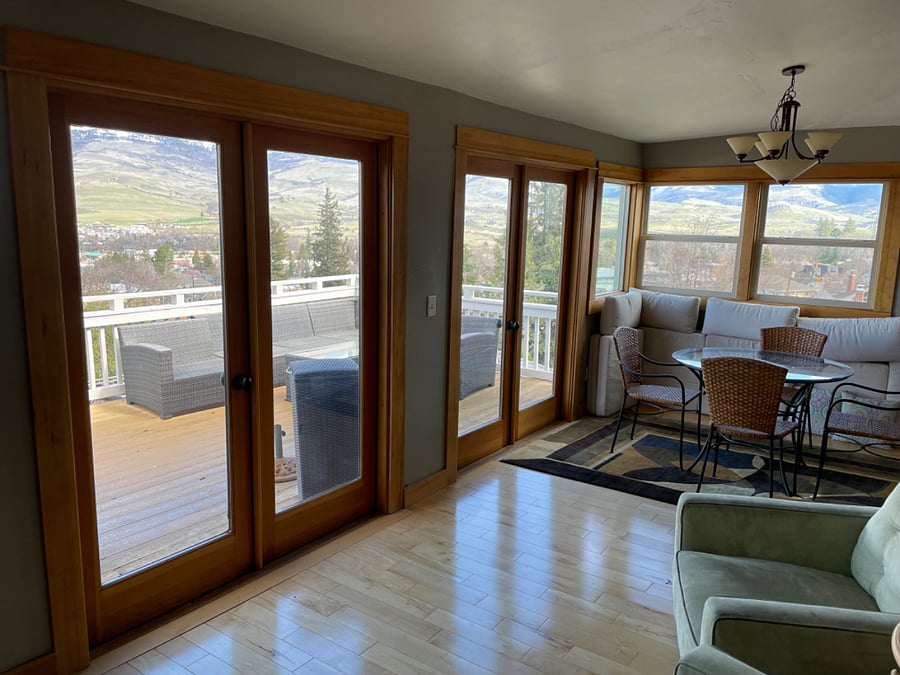 Back area with dining table and chairs, looking out at the deck/view.