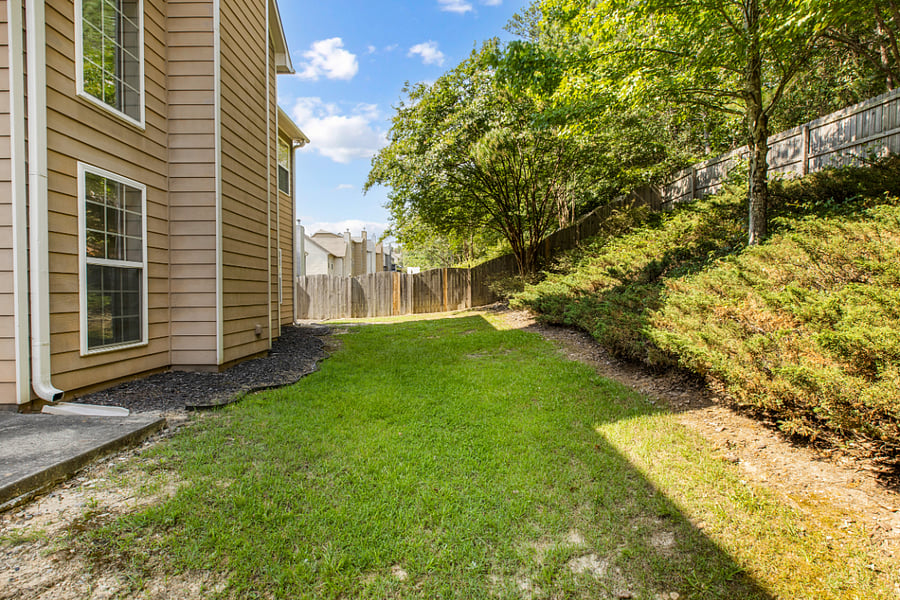 The back yard is quiet, fenced and secluded with many trees.