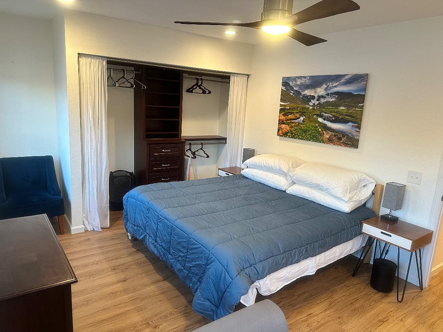 This is the primary bedroom, with Kind size bed, sit/stand desk and computer monitors.