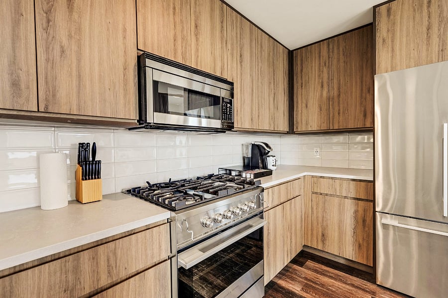 Modern Luxury Kitchen with Breakfast Bar and Dining Area- Whip up your favorite meals in this fully equipped kitchen featuring a sleek breakfast bar, modern dining setup, and elegant wood cabinetry  the perfect blend of style and function.