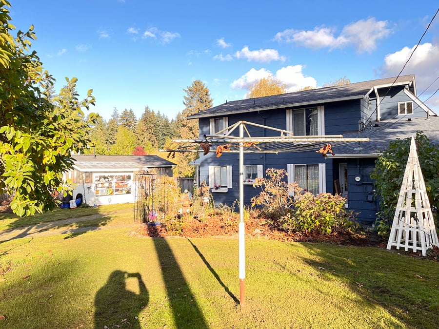 Streetside view of Main home yard with fruit trees and Clothes Line (clothes pins provided)