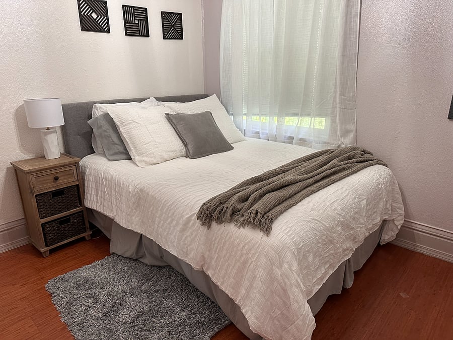 Front bedroom off the living room and next to main bathroom has a queen bed and large closet which contains a tall dresser and wall cabinet