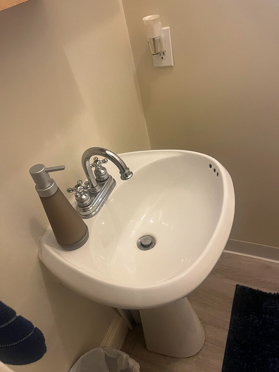 Pedestal sink in half bath of primary bedroom off kitchen