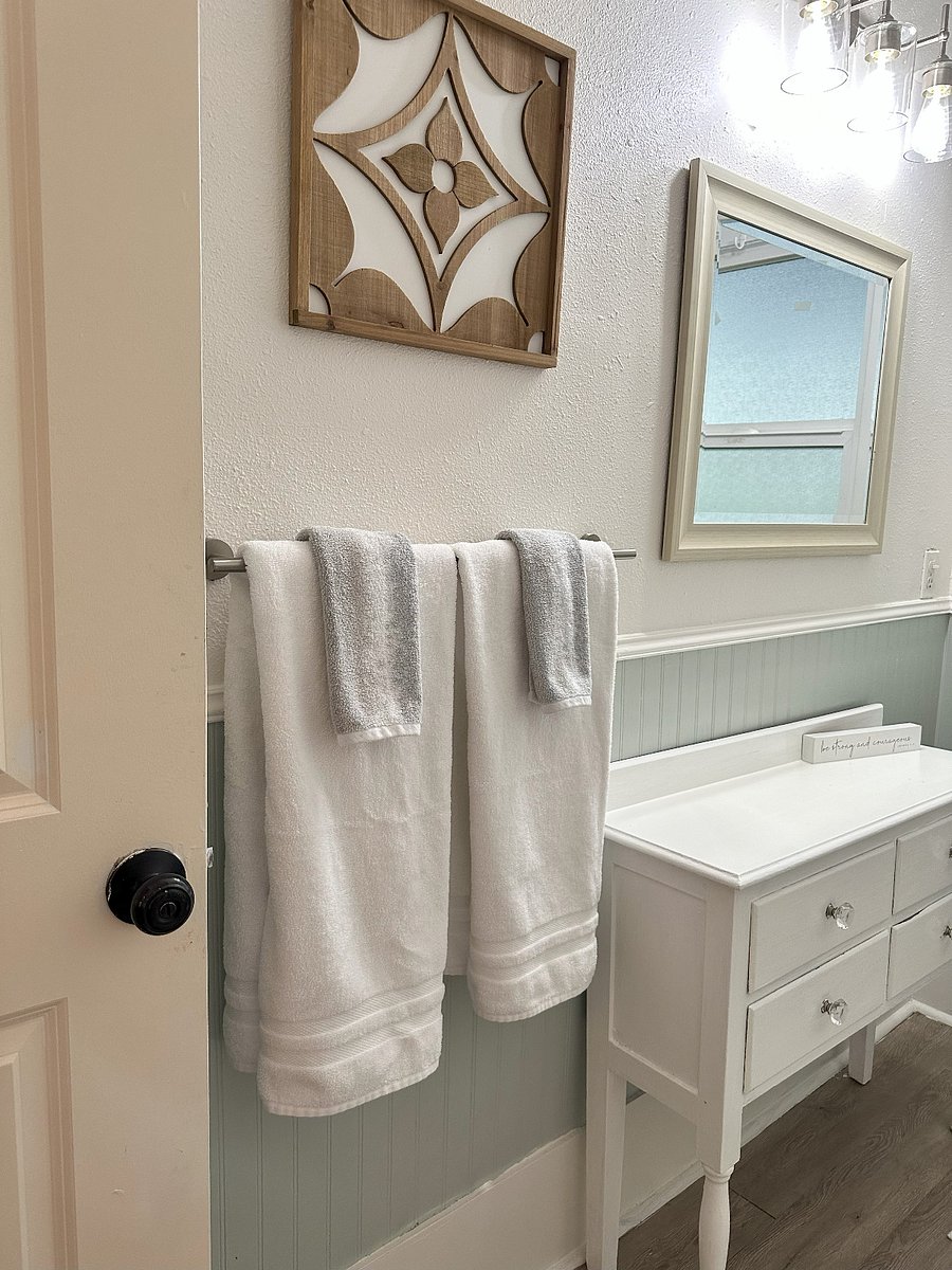 Towel bar fits two full sized towels and cabinet provides drawer and surface storage and use below wall mirror.