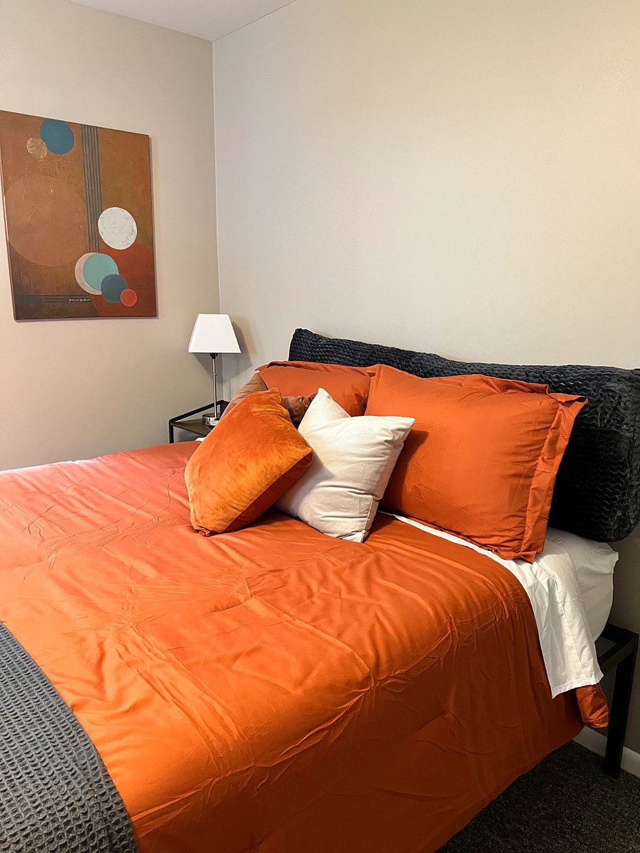 Queen bed features a memory foam mattress and suitcase storage under the bed.