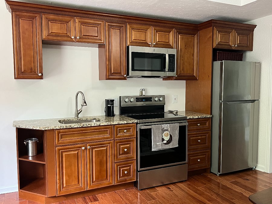 Beautiful, fully stocked kitchenette with new appliances including a full-sized refrigerator with ice-maker, microwave, range/oven, and deep sink.