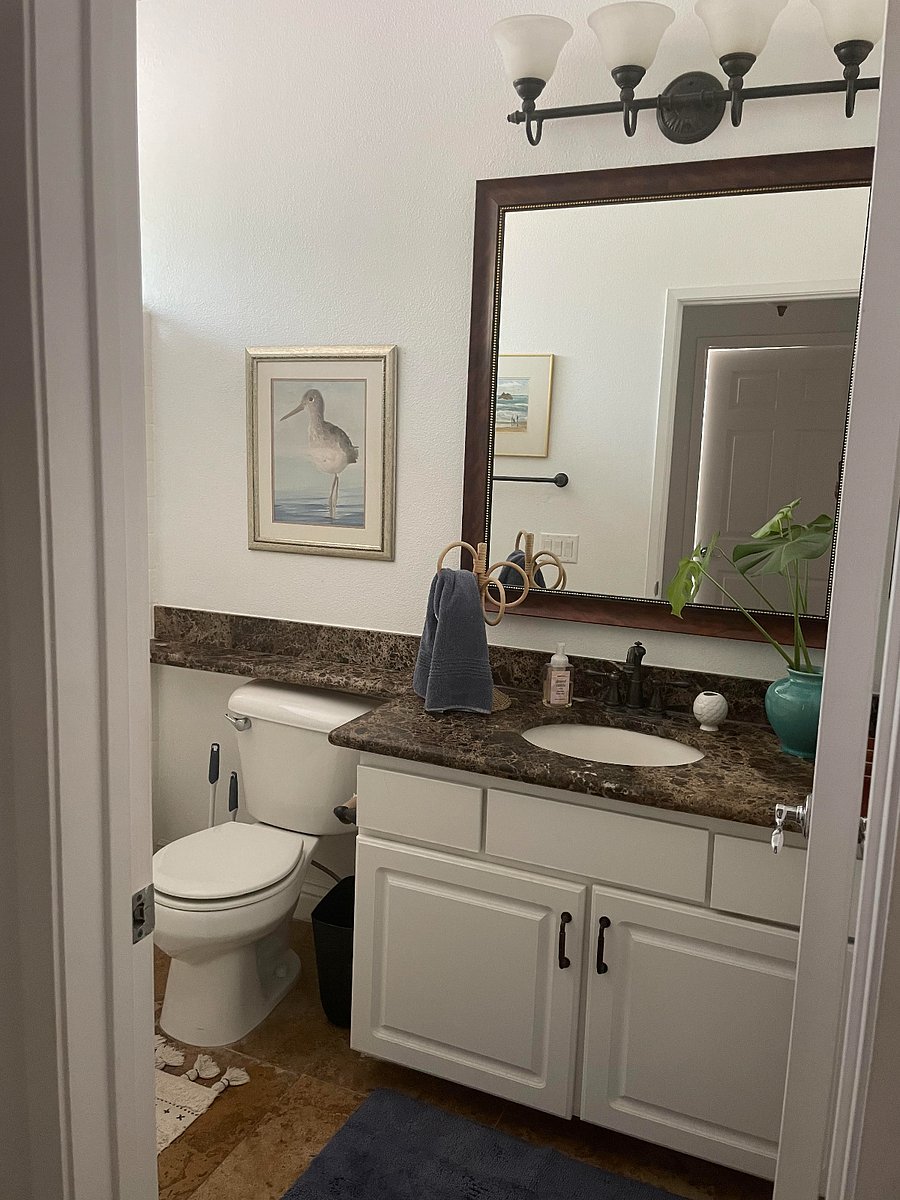 Second bathroom, end of the hall just past the primary bedroom. Artwork, bath mat, rugs, towels, wicker towel holder, and bathroom starter supplies included.