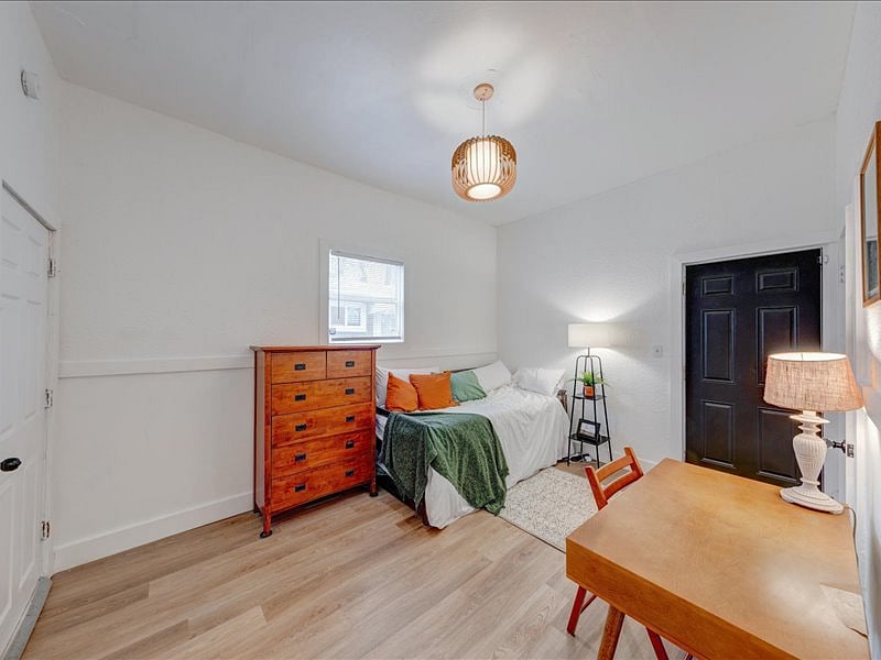 The third bedroom features a spacious closet, dresser, and desk, along with direct access to the backyard through a private door.