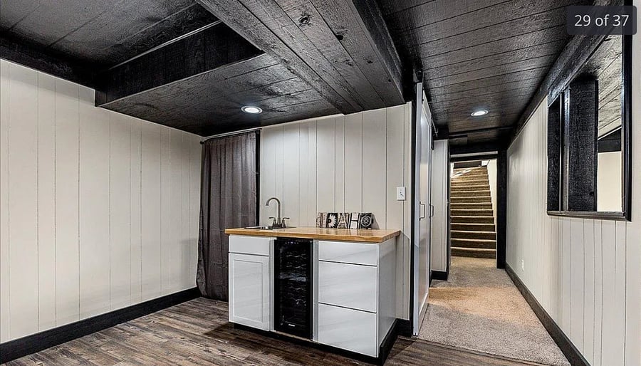 Wet bar with sink and beverage fridge. Entrance to washer and dryer to the left.