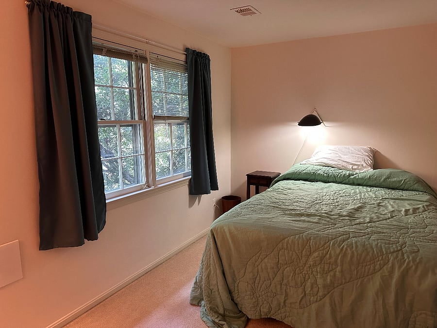 Queen bed, windows to backyard, reading lamp, bedside table.
