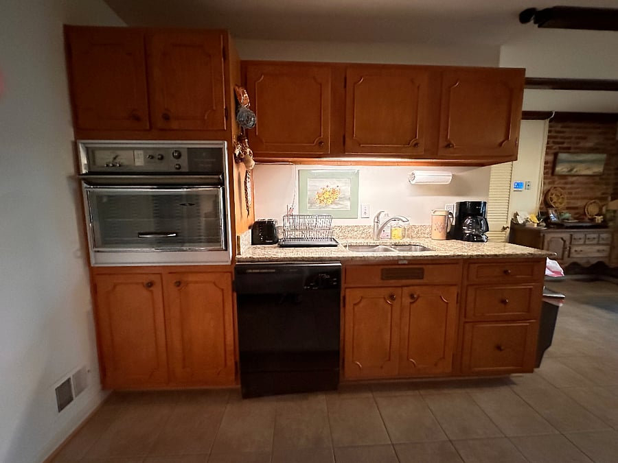 Kitchen area with wall oven, dishwasher, sinks, and coffeemaker. Other small appliances available. Food storage in cabinets and refrigerator provided.