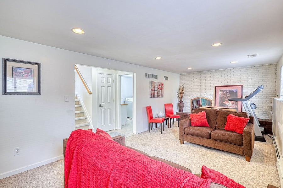 Lower-level family room with sleeping sofa, gas fireplace & treadmill