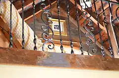 Unique features abound. View of loft with wrought iron railing.