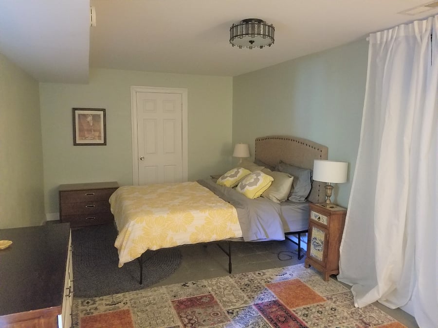 Bedroom includes queen bed, dresser, desk, closet/shelving. Through the white door you have a washer/dryer and storage