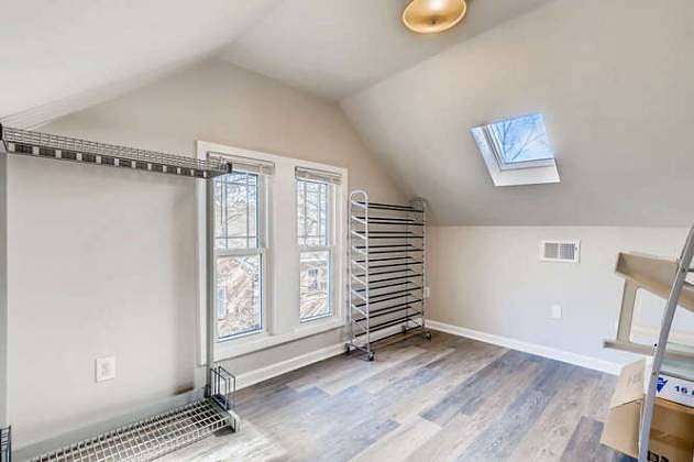 Generous storage room with extra shelves and clothes hanging.