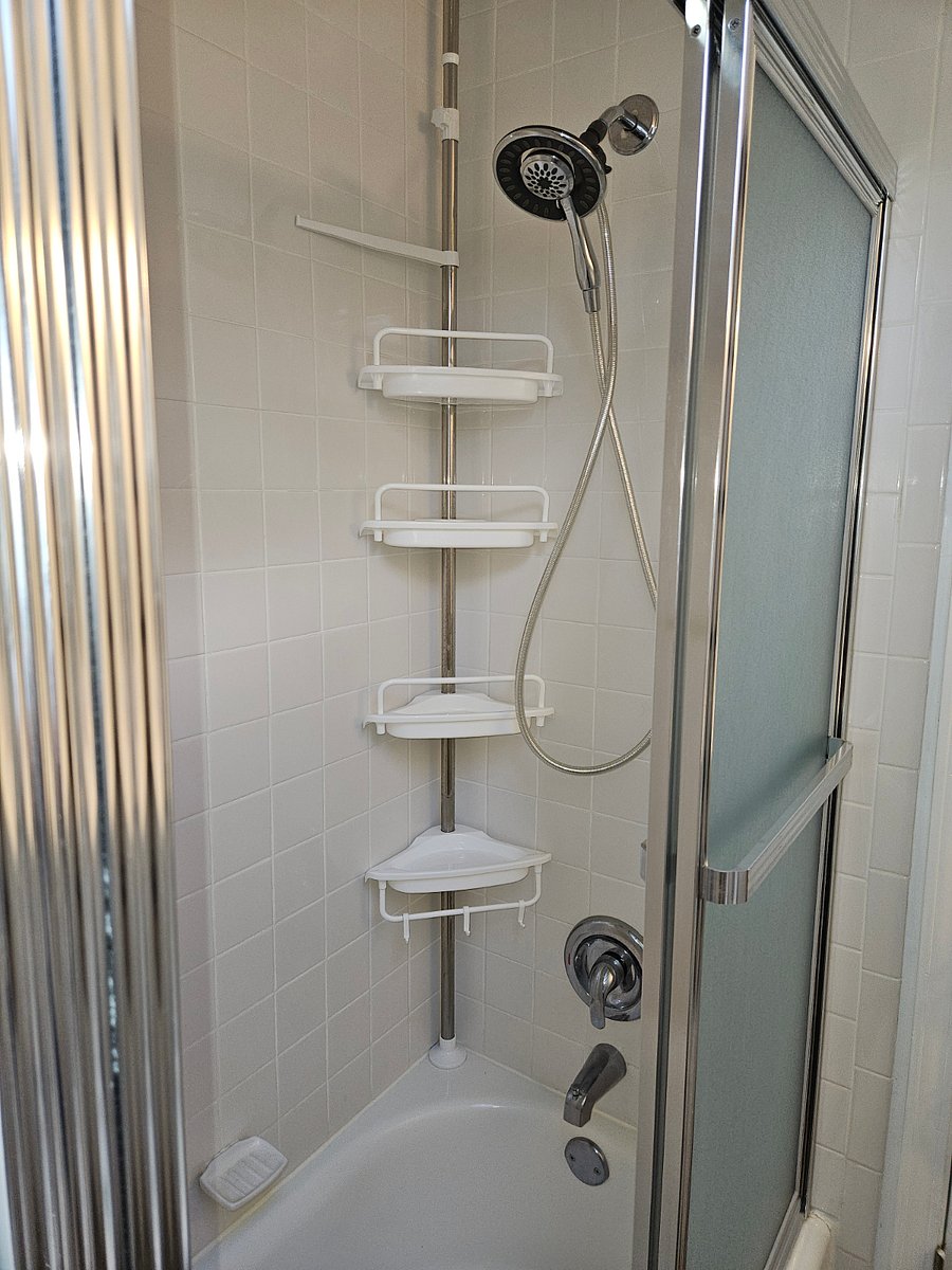 Inside the shower area includes a detachable handheld shower head, shelves for storing essential needs and a wall mounted shampoo/conditioner/body wash dispenser.