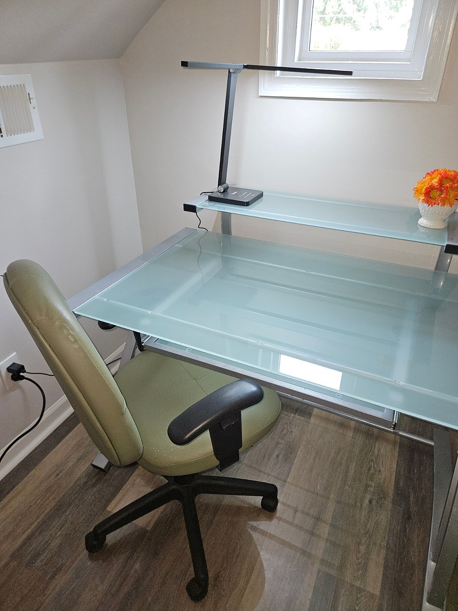 Desk with keyboard tray, adjustable lighting, chair and UPS power supply.