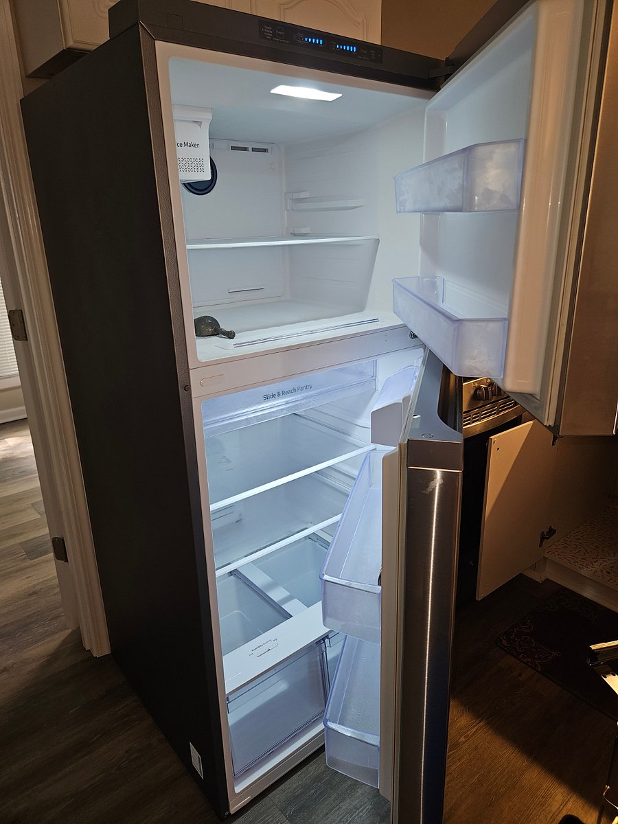 Modern full size refrigerator with ice maker.