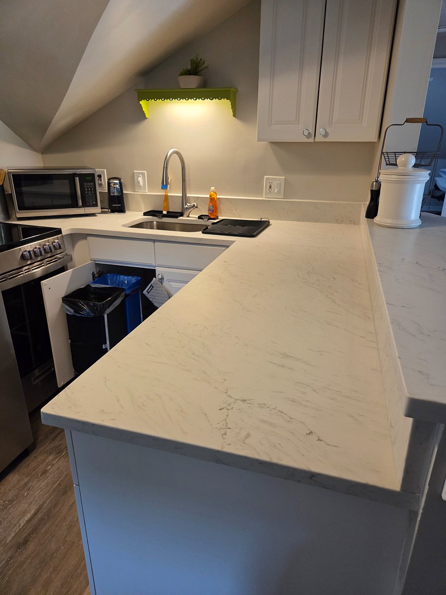 Remodeled kitchen with new counters, sink and faucet. Note trash bins slide out from under the sink.