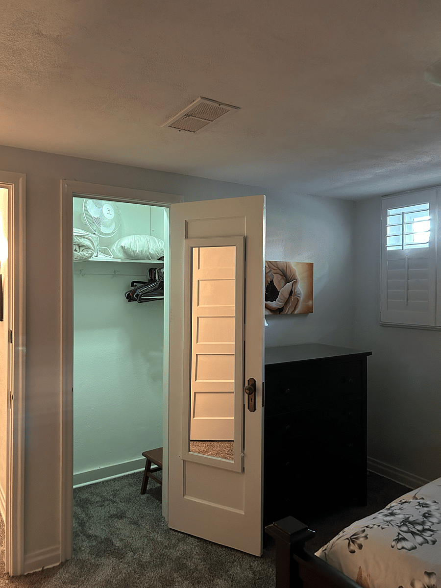 East bedroom with closet door open and door mirror