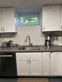Lovely kitchen window with natural light. Designer fish scale tiles line the walls.