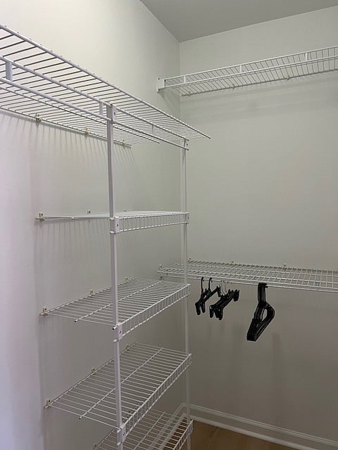 One angle of large walk in closet with shelving system in master