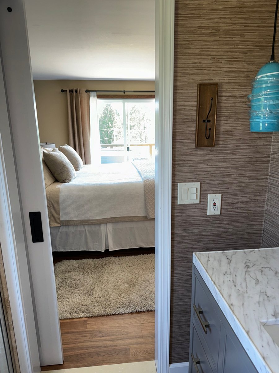Primary bedroom has bathroom next to it and slider door beyond for the hot tub use.
