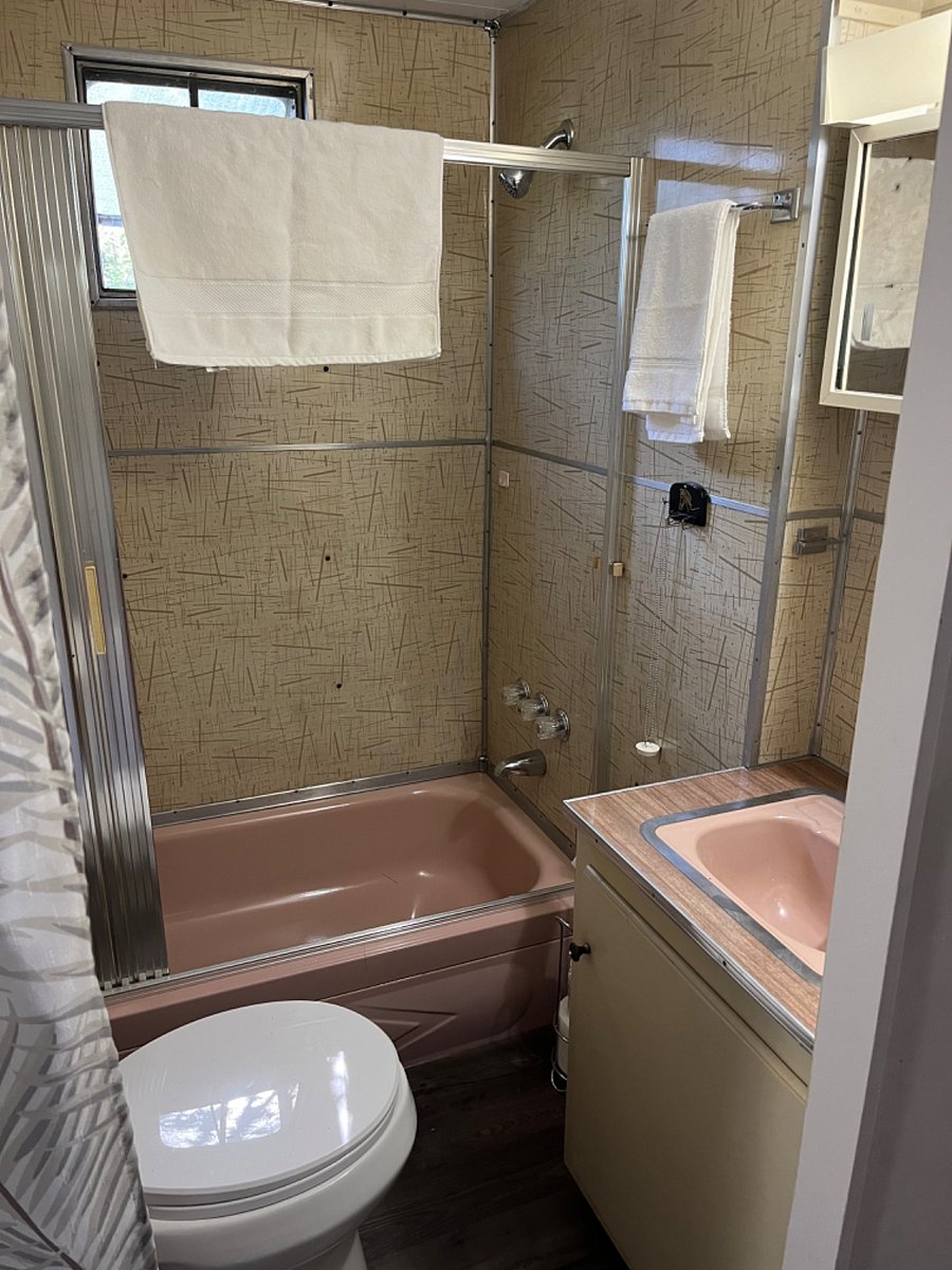 full bath adjacent to bedroom space; original decor for great 1950s vibe.