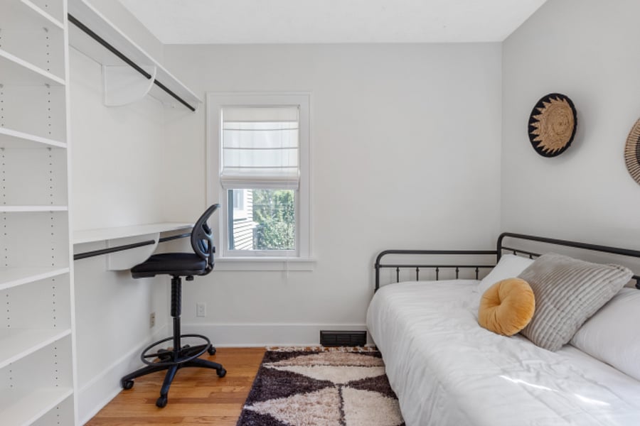 daybed room with extra closet space and a desk for working