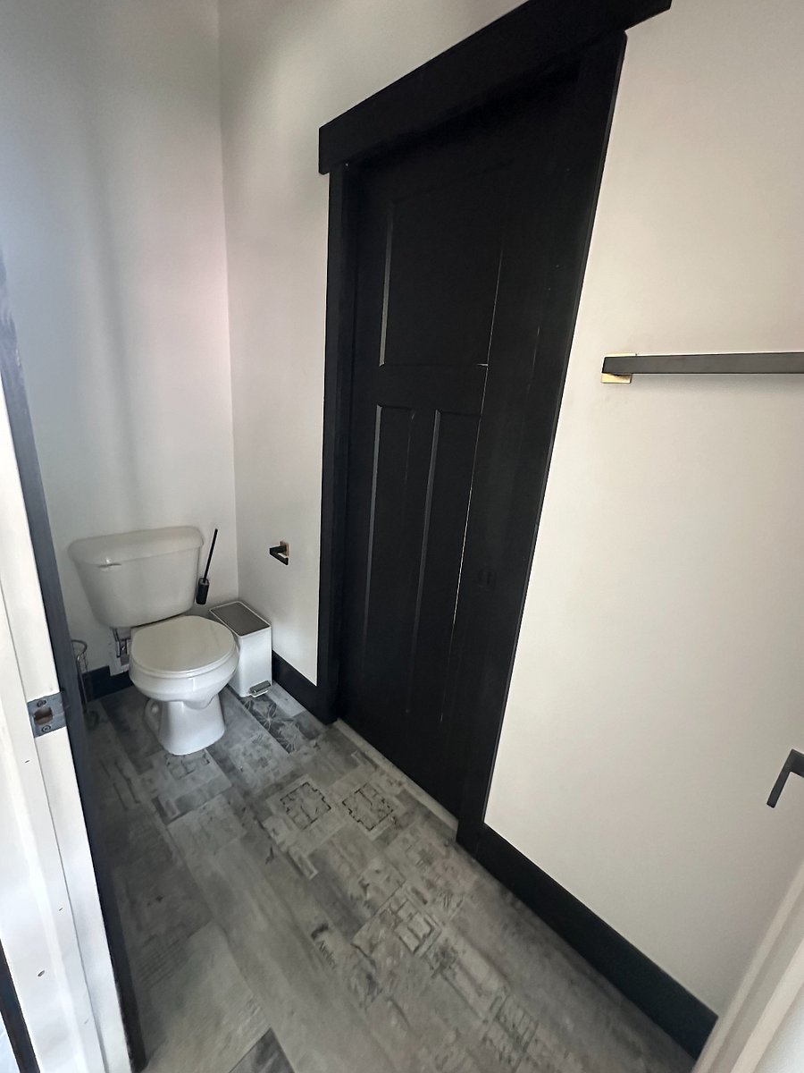Private toilet with wooden doors and pocket door separation.