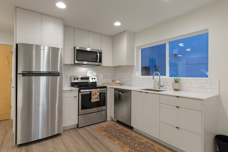 Fully-equipped kitchen w/ cookware, glass top electric range, and Whirlpool dishwasher. Soft-close cabinetry.